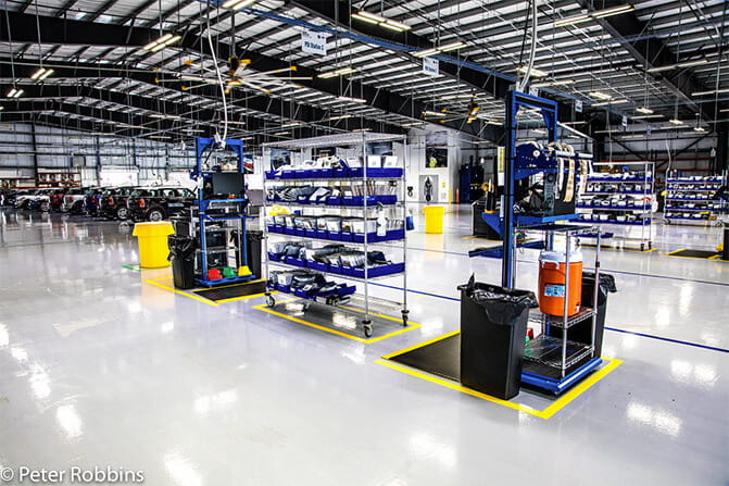Organized manufacturing workstations with yellow floor markings defining work areas and pathways