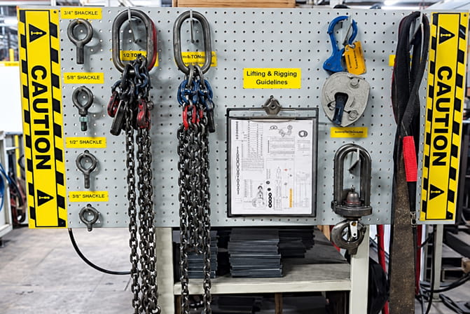 Hand tools and lifting equipment arranged on a labeled shadow board with designated storage positions