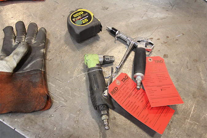 Hand tools and equipment marked with red tags for review during workplace organization