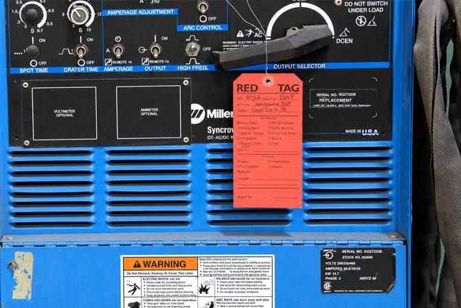 Red 5S identification tag attached to industrial equipment during a workplace sorting audit